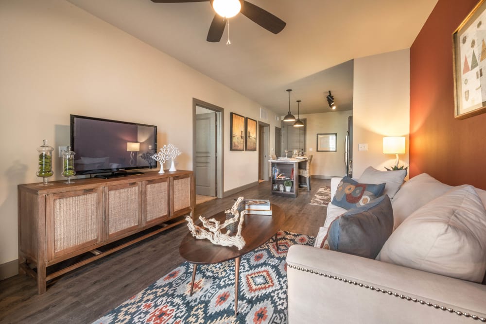 Well-furnished living area with a ceiling fan in a model home at Union At Carrollton Square in Carrollton, Texas