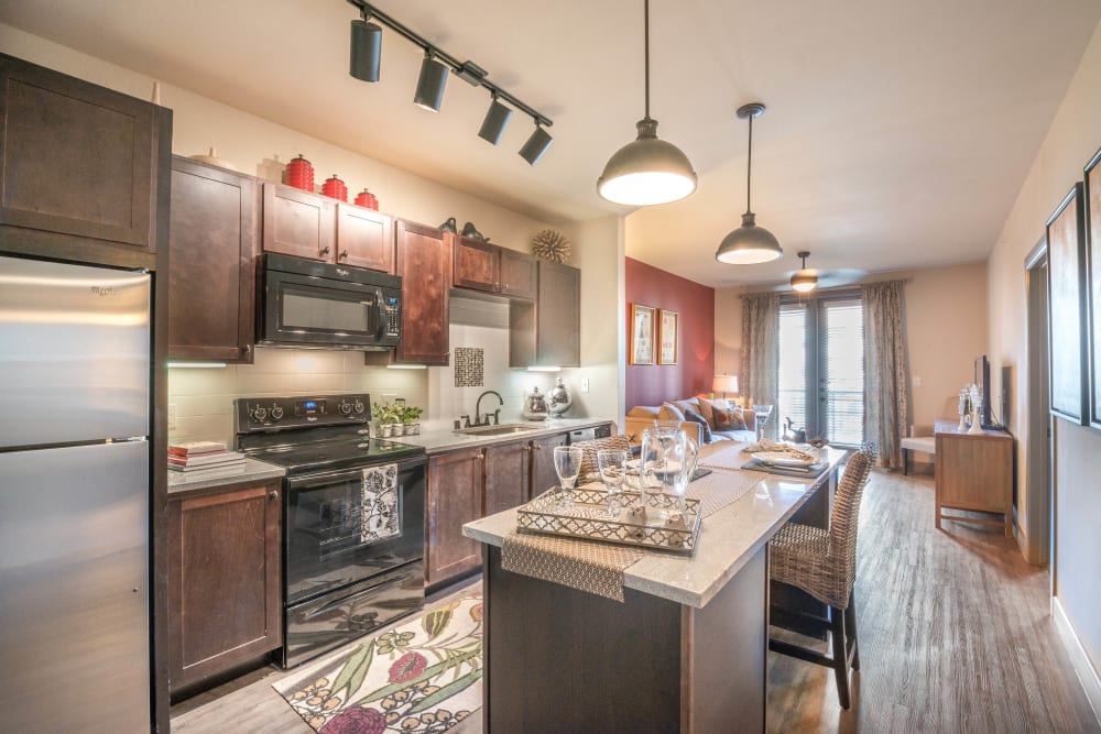 Gourmet kitchen with an island and granite countertops in a model home at Union At Carrollton Square in Carrollton, Texas