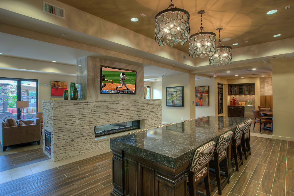 Clubhouse lounge with bar seating and flatscreen TVs at Vistara at SanTan Village in Gilbert, Arizona