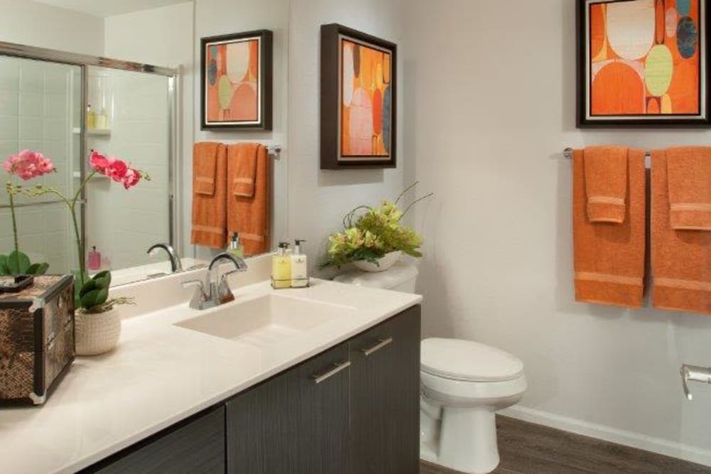 Quartz countertop and a large vanity mirror in a model home's bathroom at Vive in Chandler, Arizona