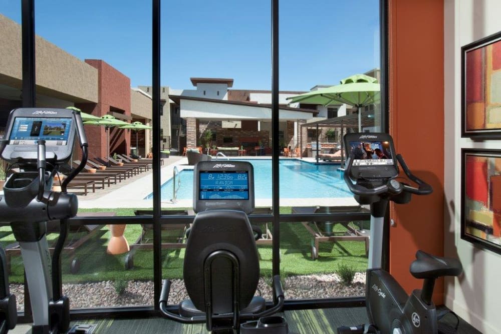 View of the swimming pool from the cardio machines in the fitness center at Vive in Chandler, Arizona