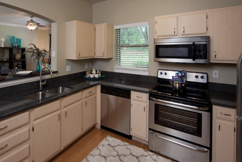 Model apartment's gourmet kitchen with granite countertops at Wimberly at Deerwood in Jacksonville, Florida