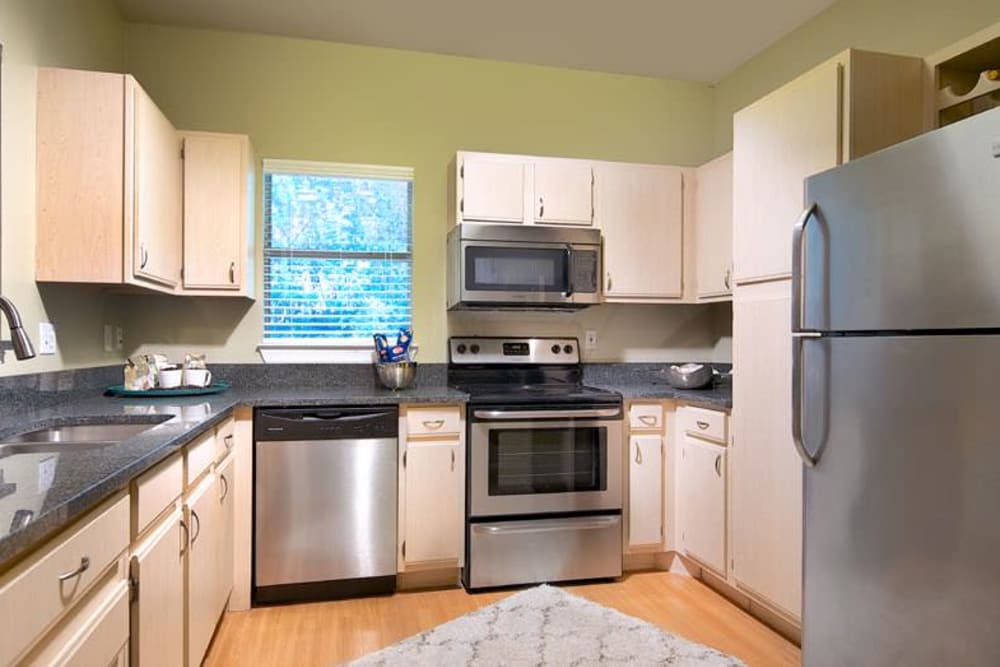 Light wood cabinetry and stainless-steel appliances in a model home's kitchen at Wimberly at Deerwood in Jacksonville, Florida