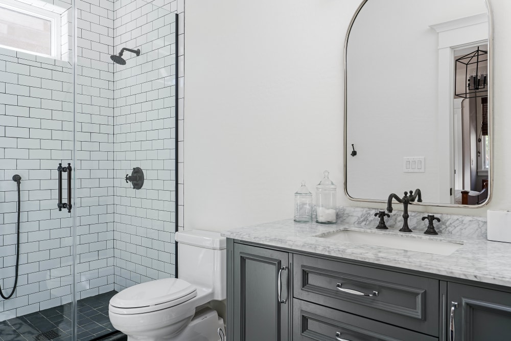 Tiled shower in a model home's bathroom at Olympus Court Apartments in Bakersfield, California