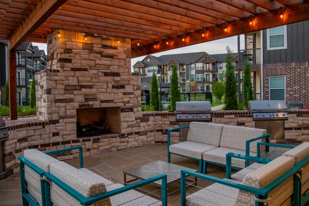Outdoor lounge with a fireplace at Bend at New Road Apartments in Waco, Texas