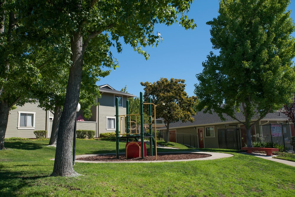 A children's playground surrounded by grass at Ridgecrest Apartment Homes in Martinez, California