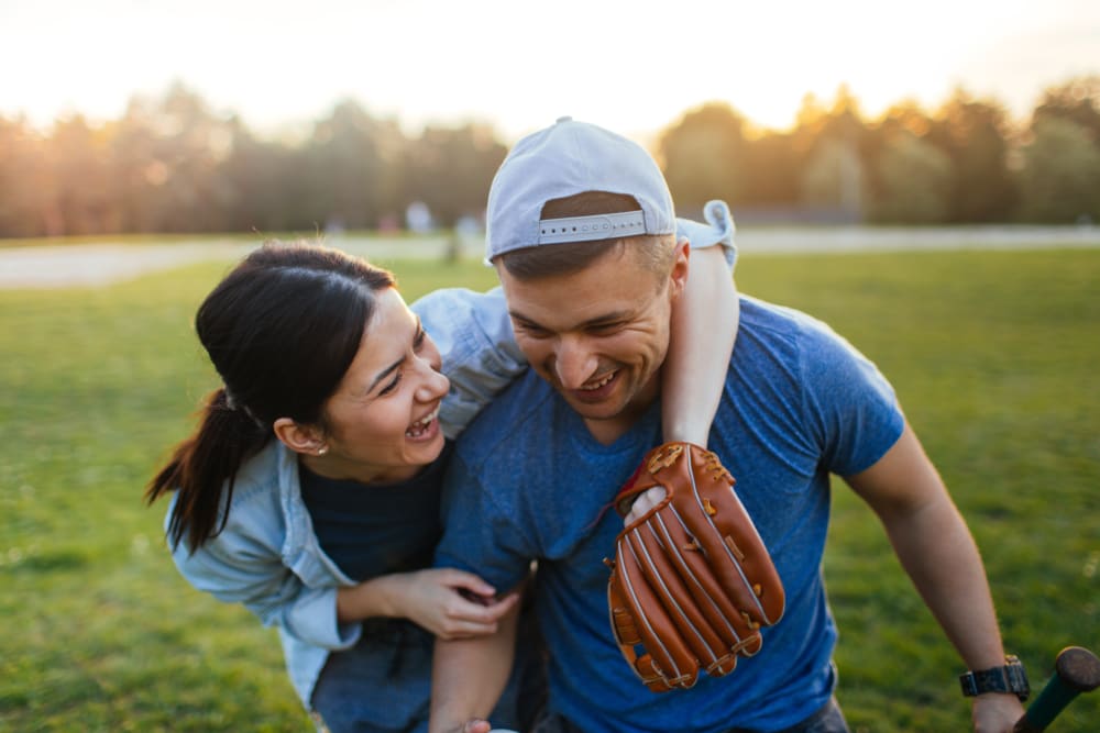 Couple playing baseball together near UNCOMMON Raleigh in Raleigh, North Ca...