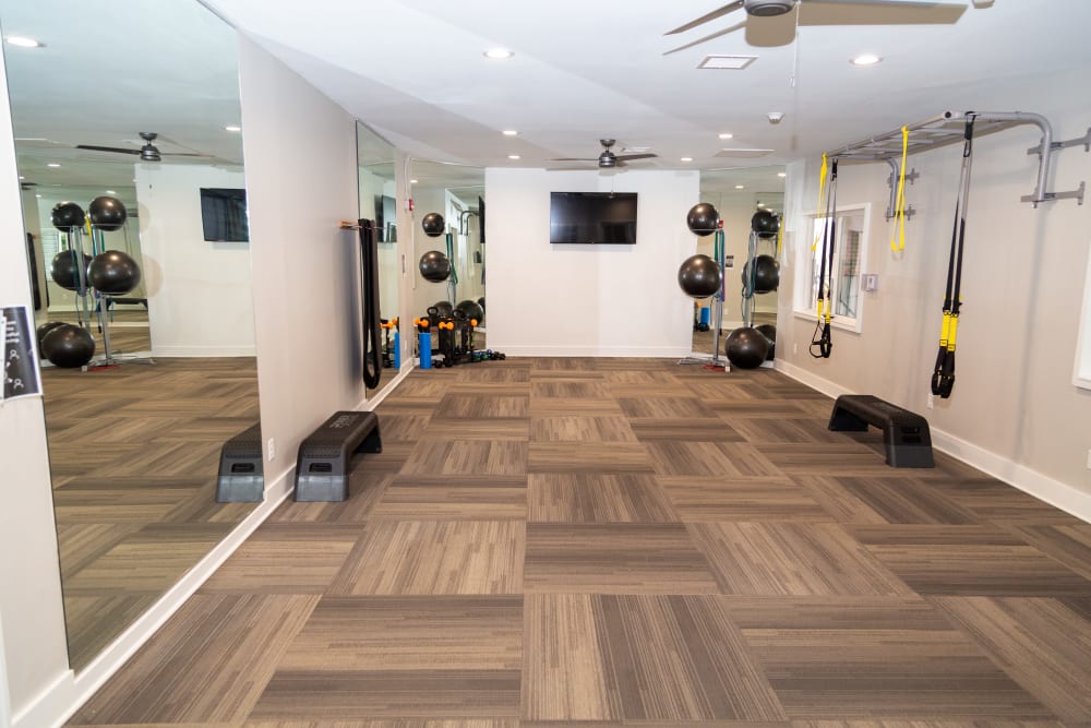 A fitness center with a flat-screen TV at Sunbrook Apartments in Saint Charles, Missouri