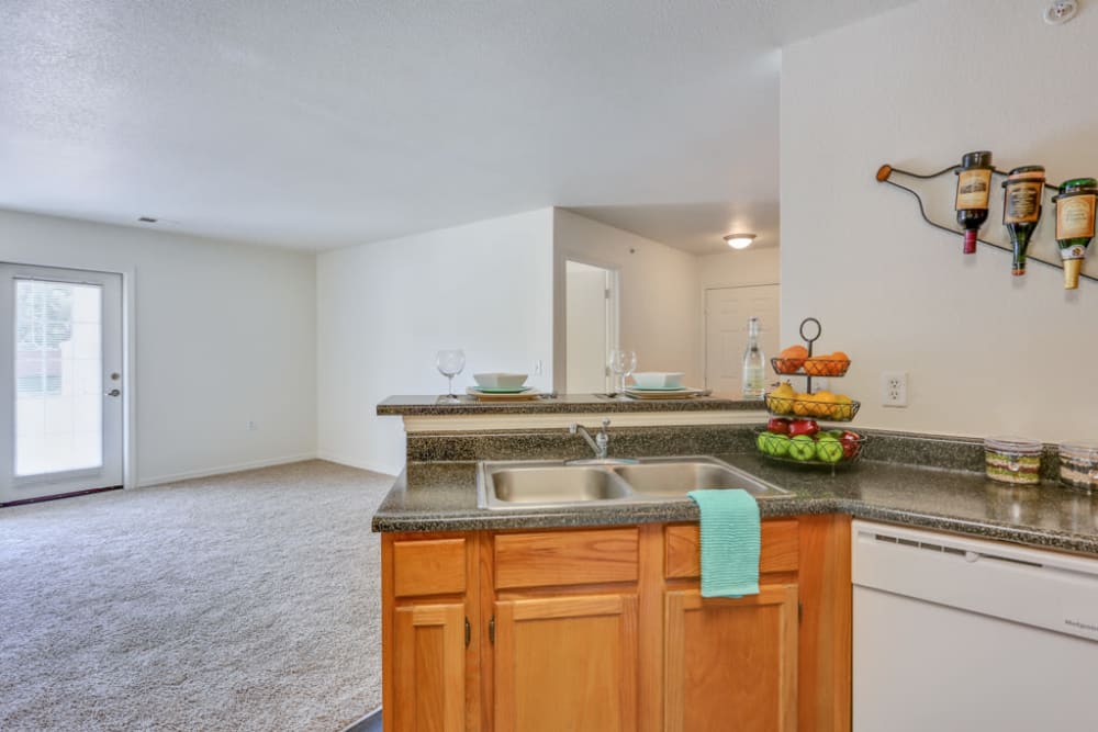 Spacious kitchen with dark counters and wood cabinets at Buffalo Run Apartments in Fort Collins, Colorado