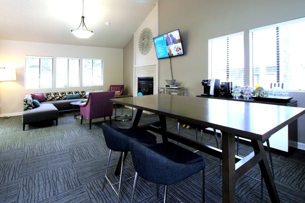 Clubhouse with a flat screen TV and bar-style seating at Plum Tree Apartment Homes in Martinez, California