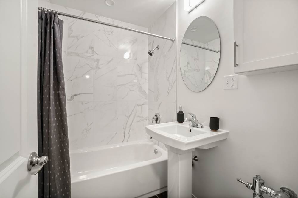 Bathroom with bathtub and custom backsplash at Camelot Court in Brighton, Massachusetts