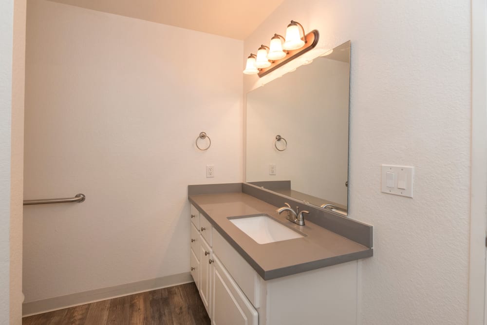 Bathroom with wood-style flooring at Sterling Heights Apartment Homes in Benicia, California