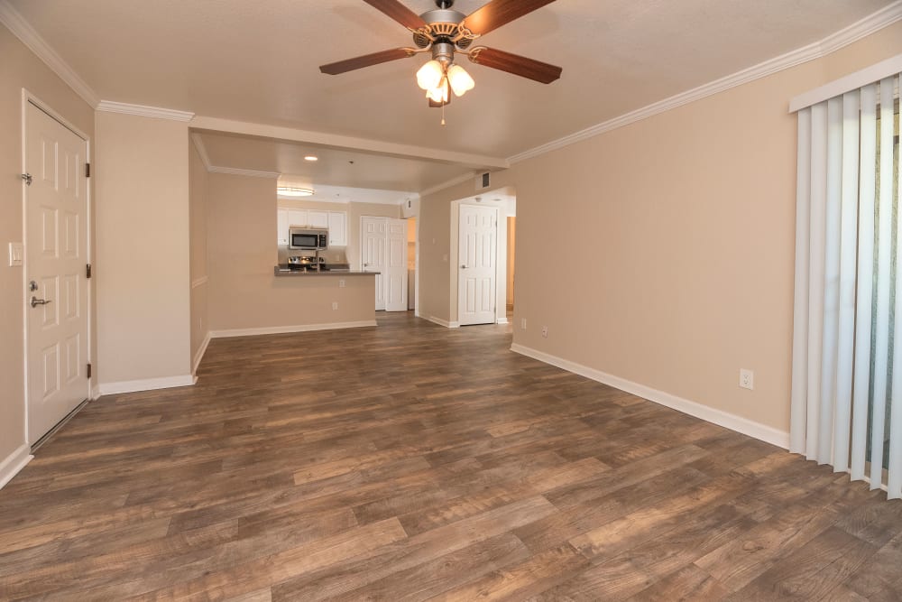 Living room with wood-style flooring and patio access at Sterling Heights Apartment Homes in Benicia, California