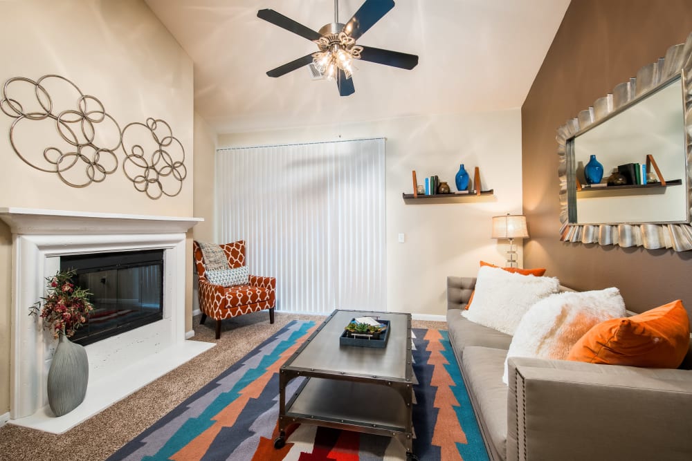 Fireplace and a ceiling fan in the well-furnished living area of a model home at Reserve at Pebble Creek in Plano, Texas