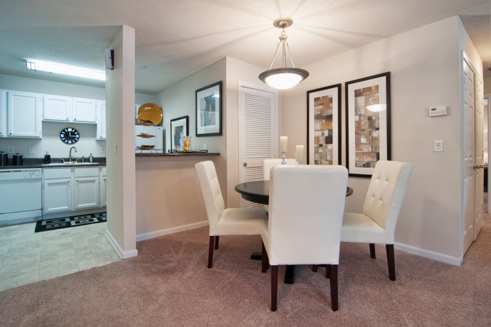 Open-concept layout with plush carpeting and custom lighting over the dining area in a model home at Bellingham Apartment Homes in Marietta, Georgia