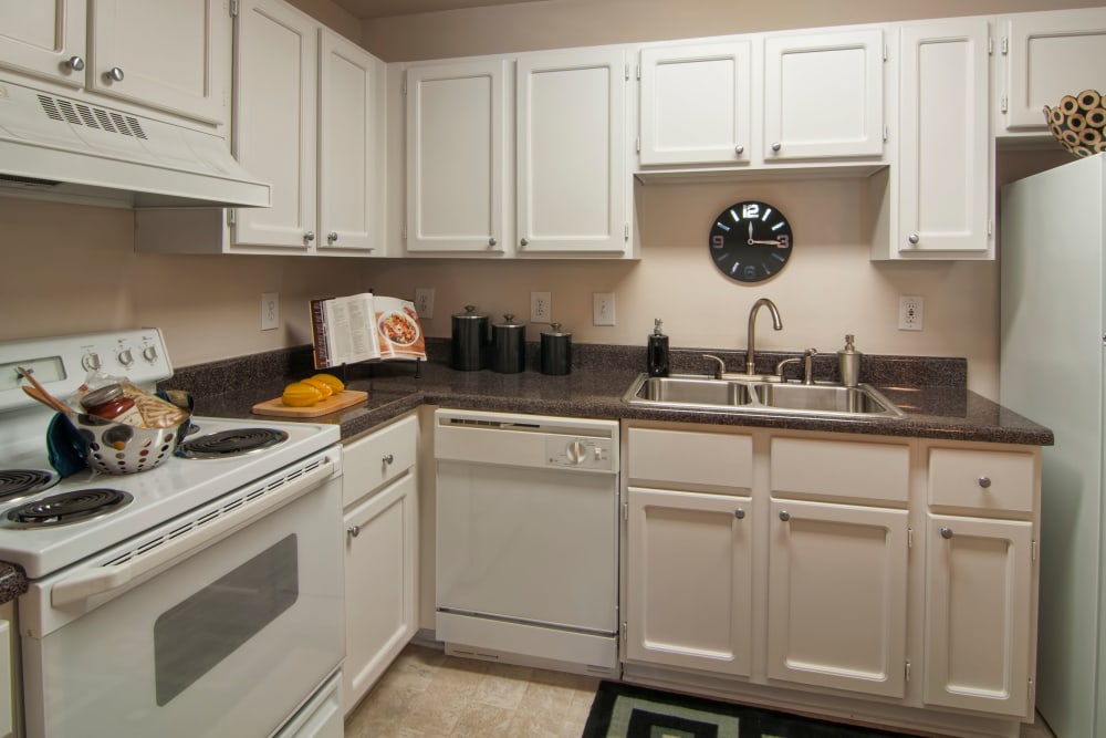 Modern kitchen with granite countertops and ample cupboard space in a model home at Bellingham Apartment Homes in Marietta, Georgia