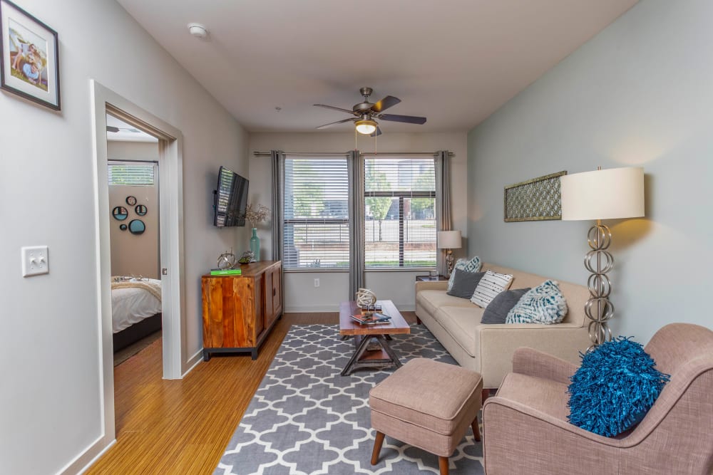 Comfortably furnished living space with a ceiling fan in a model home at Olympus Midtown in Nashville, Tennessee