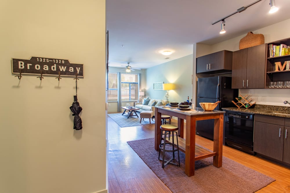 Large open-concept kitchen with an island and rich wood cabinetry in a model home at Olympus Midtown in Nashville, Tennessee