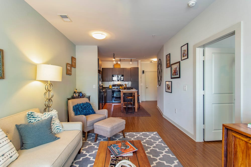 Large open-concept living space with comfortable furnishings in a model home at Olympus Midtown in Nashville, Tennessee