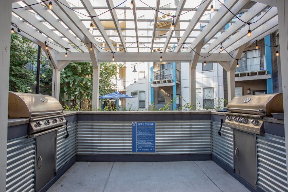 Gas grills and a pergola overhead at the barbecue area at Olympus Midtown in Nashville, Tennessee