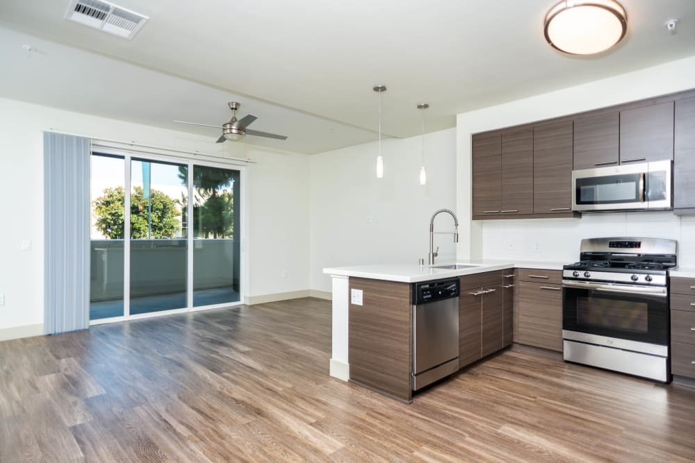 Sliding door to the private balcony outside a model home's open-concept kitchen at Fusion Apartments in Irvine, California