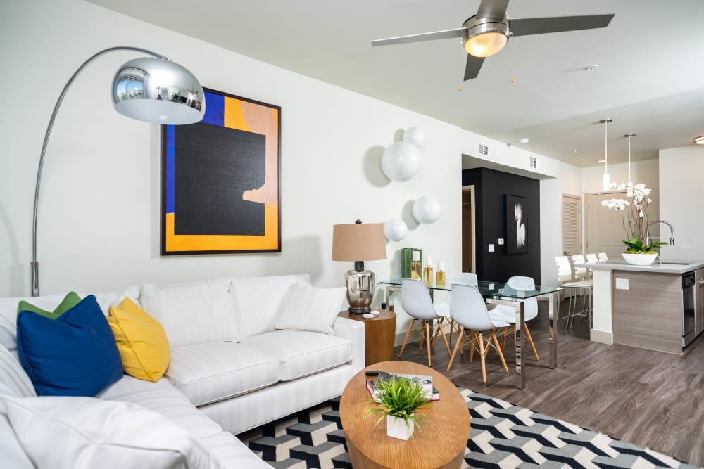 Modern art and a ceiling fan in the living area of a model apartment at Fusion Apartments in Irvine, California
