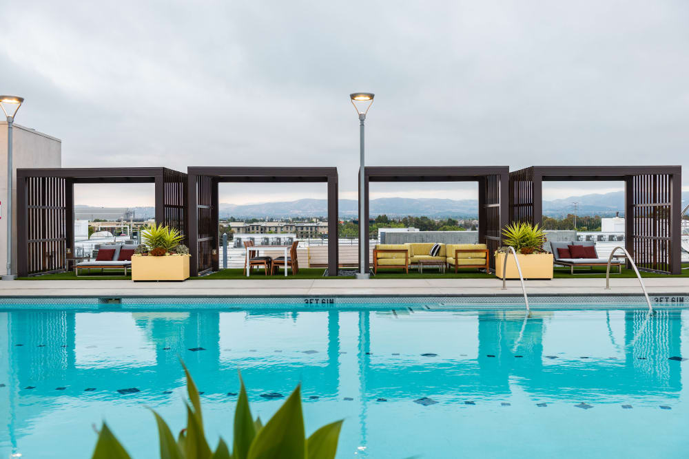 Private cabanas next to the rooftop resort-style swimming pool at Fusion Apartments in Irvine, California