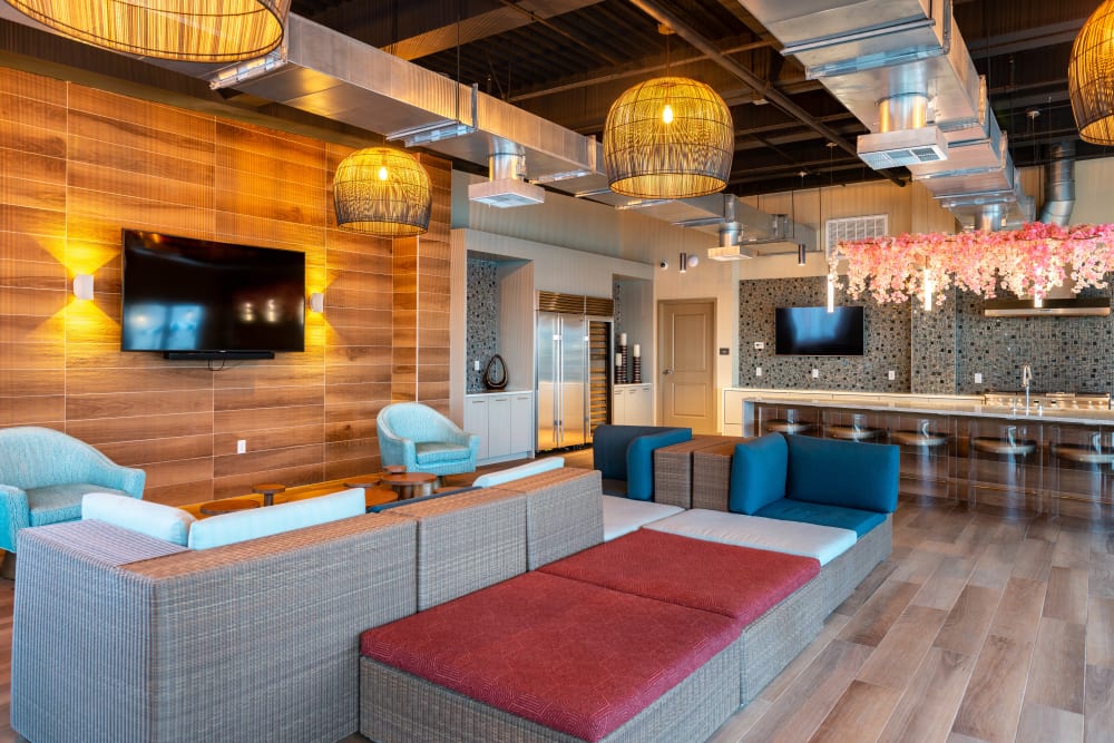 Resident clubhouse lounge with flatscreen TVs at Fusion Apartments in Irvine, California