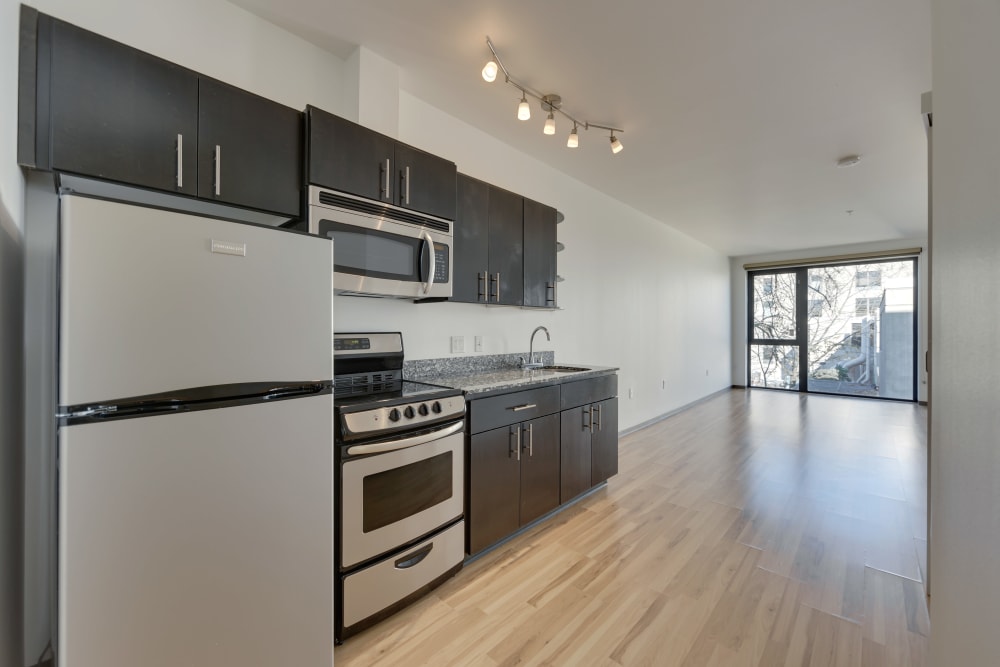 Modern, sleek kitchen with wood-style flooring at Milano in Portland, Oregon