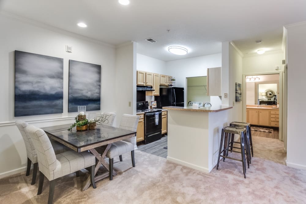 An apartment dining room and kitchen at The Enclave at Deep River in Greensboro, North Carolina