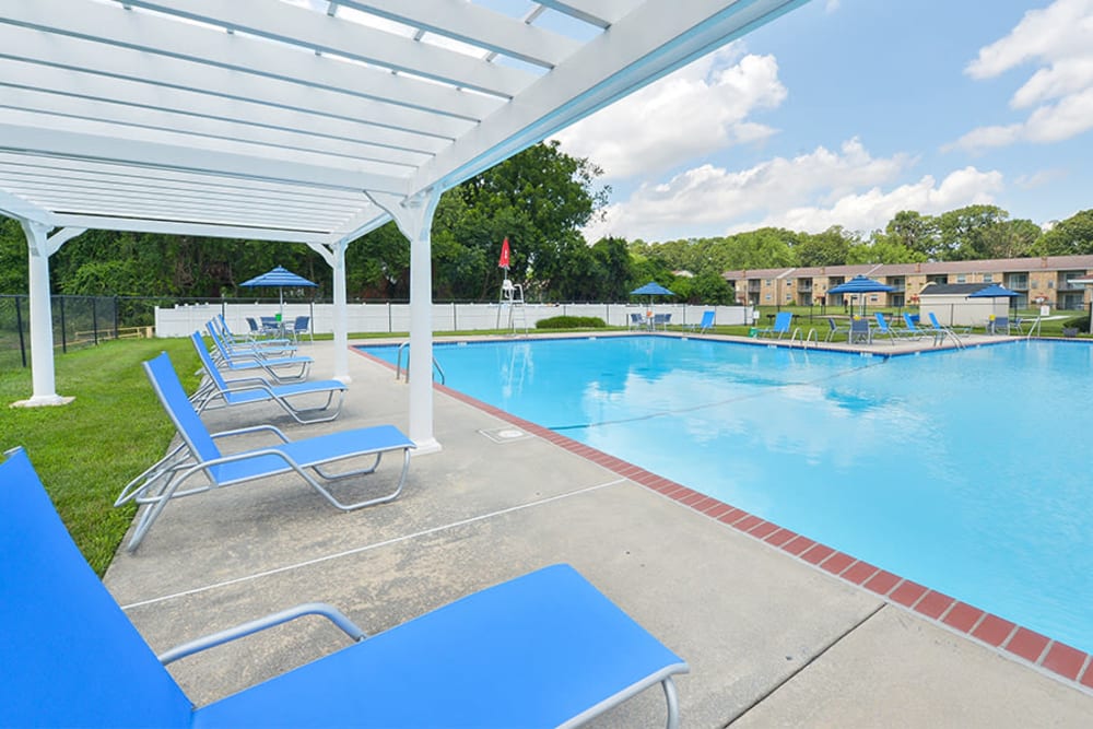Swimming pool with sundeck lounge seating under a pergola at The Fairways Apartment Homes in Blackwood, New Jersey