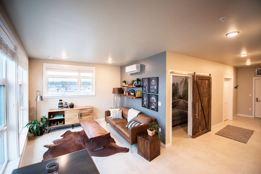 Open-concept living area with reclaimed barn wood doors in a model apartment at Brooklyn Yard in Portland, Oregon