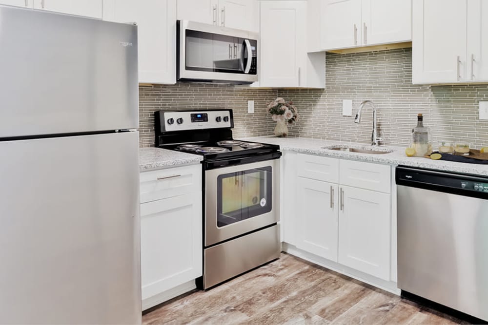 Modern kitchen with stainless-steel appliances and custom white Shaker cabinetry at Marchwood Apartment Homes in Exton, Pennsylvania