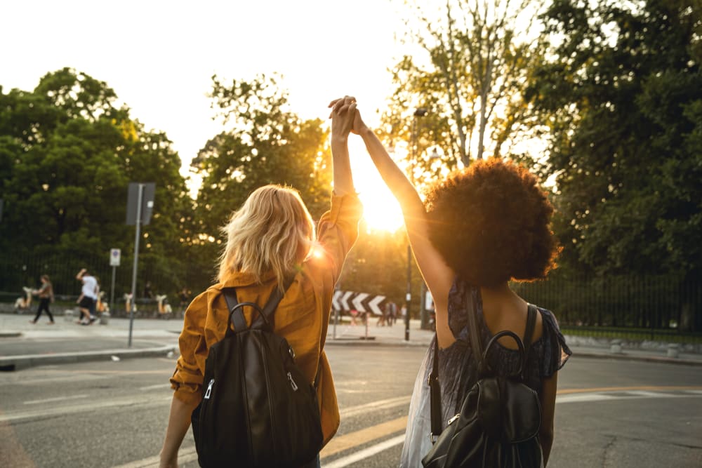 Friends holding hands while looking at the sunset at evolve Bloomington in Bloomington, Indiana