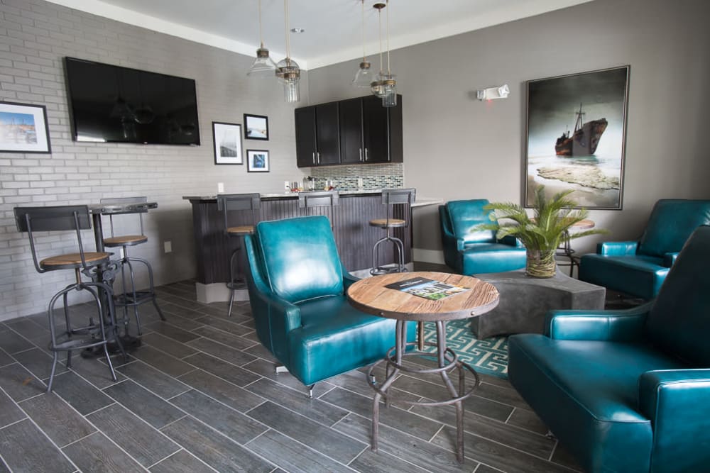 Clubhouse lounge with bar seating and flat-screen TVs at Ansley Commons Apartment Homes in Ladson, South Carolina