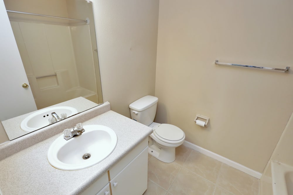 Model bathroom with large vanity mirror at Stonewood Townhomes in Melbourne, Florida
