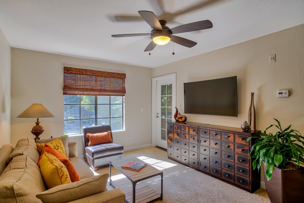 Staged living room with ceiling fan at Shadow Creek Apartments