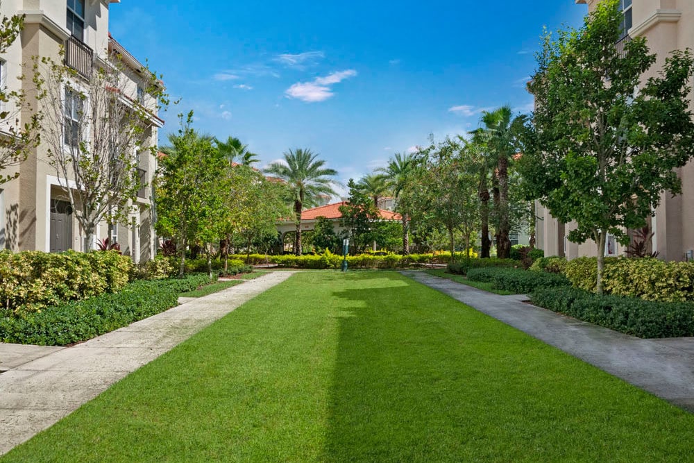 Sidewalks by well manicured lawn outside apartment building at City Center on 7th Apartment Homes in Pembroke Pines, Florida