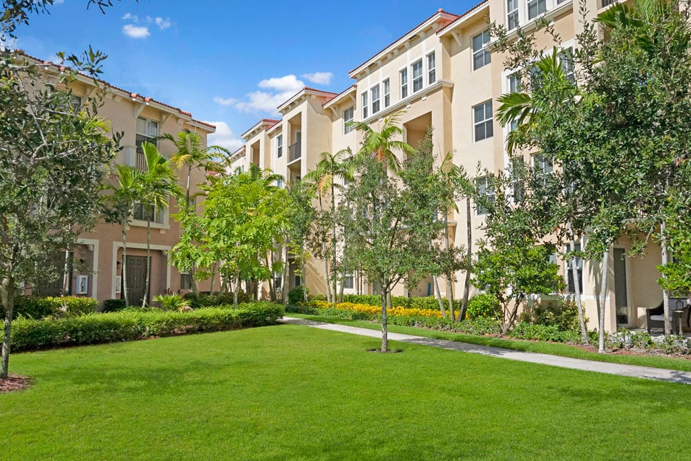 Exterior image of buildings and grassy lawn area at City Center on 7th Apartment Homes in Pembroke Pines, Florida