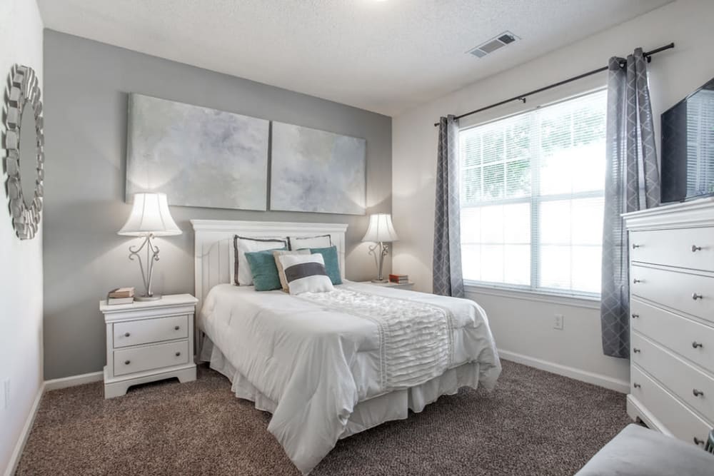 Well decorated bedroom featuring a large window for natural light at Eastwood Village in Stockbridge, Georgia