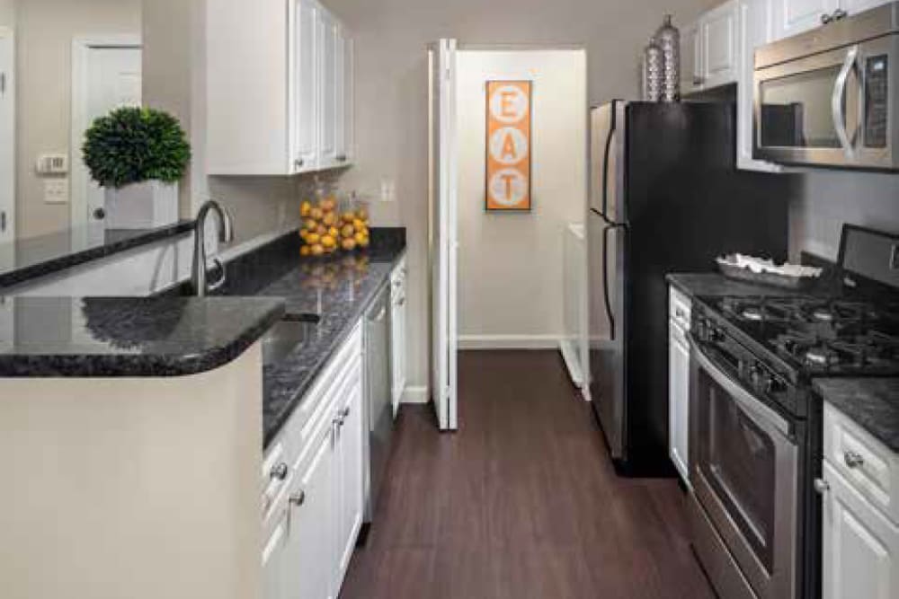 Kitchen featuring black appliances in ample countertop space at Ellington Metro West in Westborough, Massachusetts