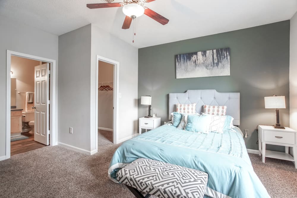 Model bedroom with large windows and ceiling fan at Meadow View in College Park, Georgia