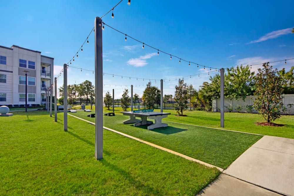 Cornhole game and outdoor ping-pong table at Linden on the GreeneWay in Orlando, Florida