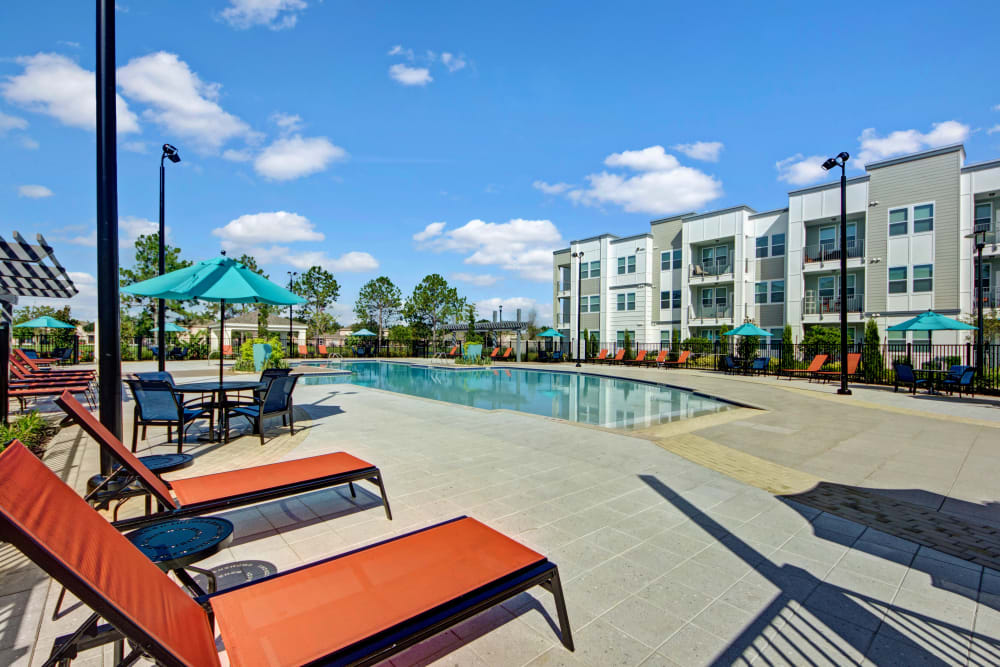 Lounge chairs beside the community pool at Linden on the GreeneWay in Orlando, Florida