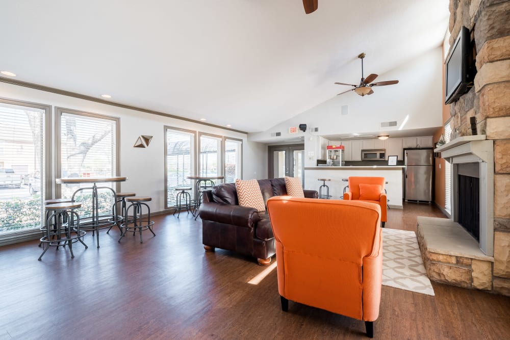 Brightly lit clubhouse with kitchen and fireplace at The Fairway Apartments in Plano, Texas