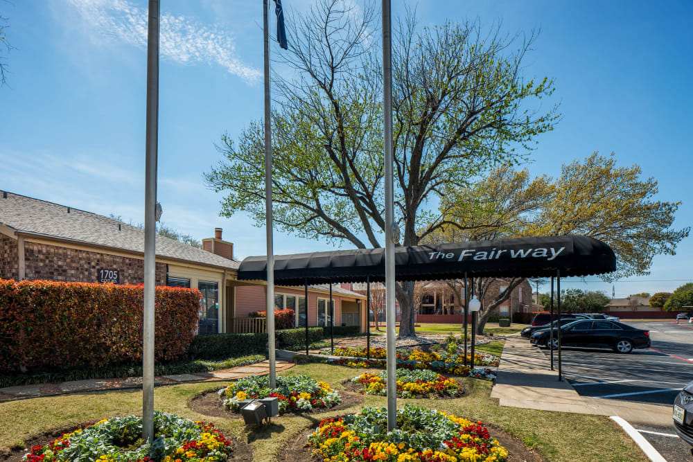Well-maintained landscape at the entrance of The Fairway Apartments in Plano, Texas