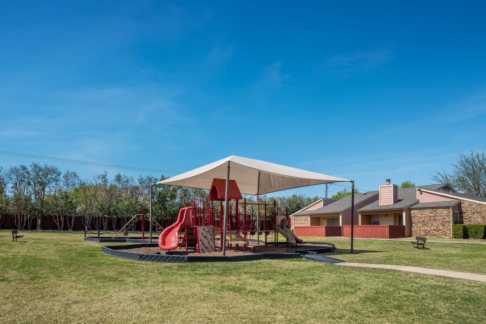Children's playground and lawn space at The Fairway Apartments in Plano, Texas