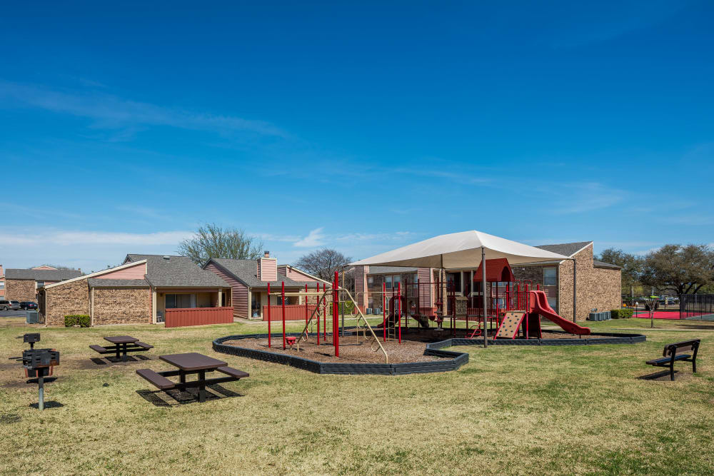 Children's playground and picnic area at The Fairway Apartments in Plano, Texas