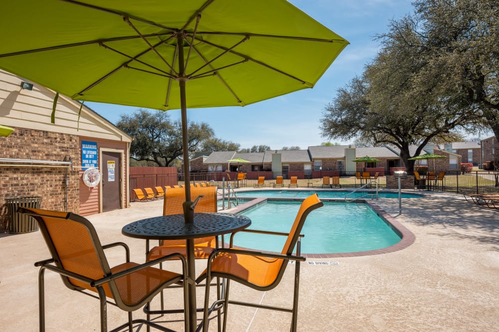 Another view of the multiple pools from the shaded chairs at The Fairway Apartments in Plano, Texas
