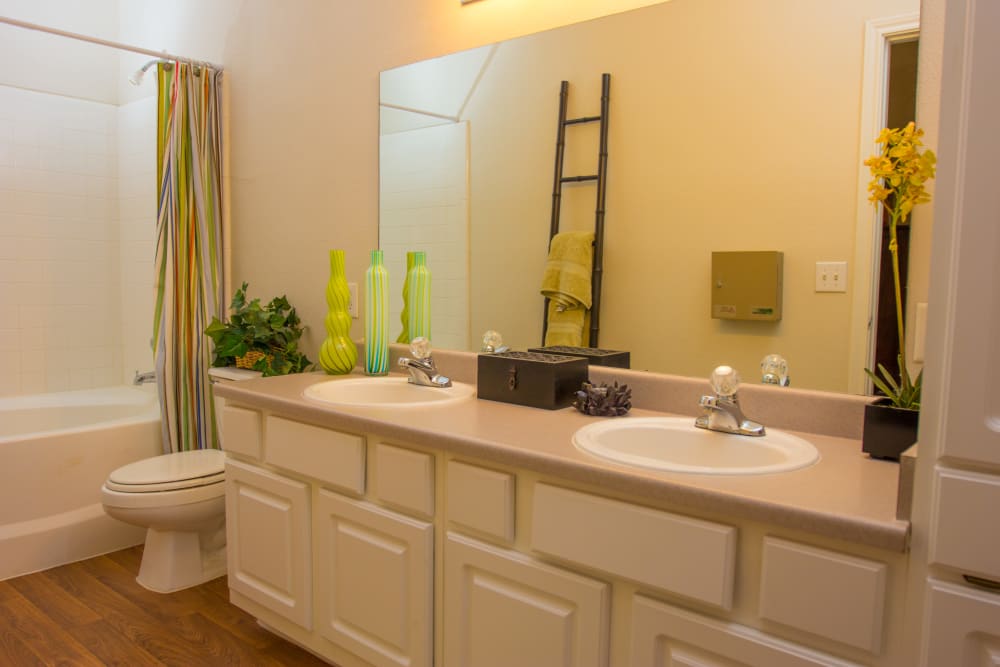 Large model bathroom with two sinks and oval tub at The Lodge at River Park in Fort Worth, Texas